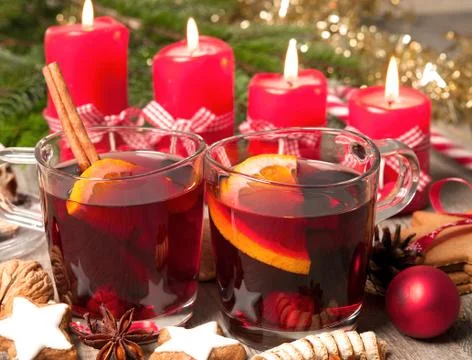 Red mulled wine on table with burning candles Stock Photos