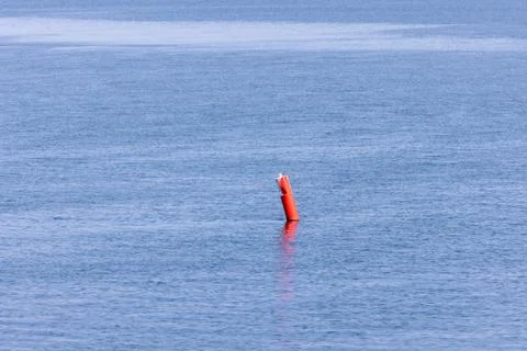 Red navigation buoy floating on calm coastal waters in Prince Edward Island.. Foto stock