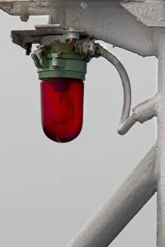 Red navigational light on the port side of a ship. Stock Photos