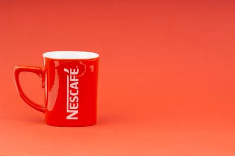 Red Nescafe mug isolate on red background 스톡 사진