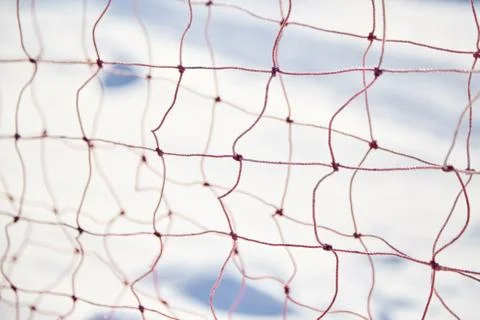 Red net of synthetic threads on a blurred snowy background. Selective focus Foto stock