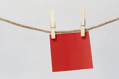 Red note paper hanging on rope on white wall. Foto stock