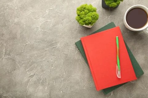 Red notebook with coffee cup and pencil on grey background. Flat lay, creativ Stock Photos