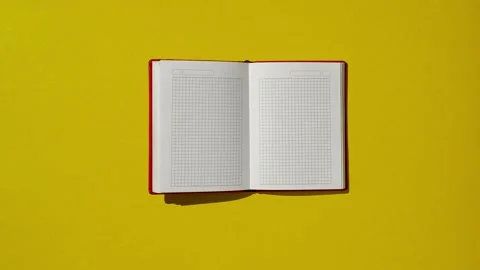 Red notebook diary on yellow office table at home workspace for notes Stock Footage 220601192