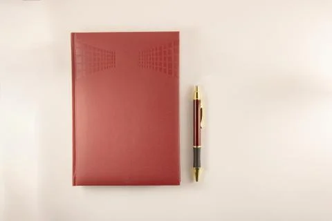 Red notebook with pen on white background Foto stock