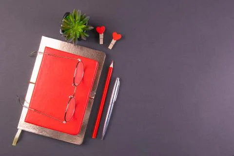 The red notebook stands on a gold notebook which stands on a black background Stock Photos