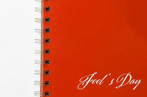 Red notebook with text FOOL'S DAY on white background. Stock Photos