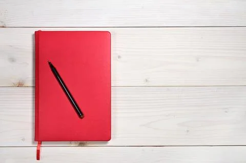 Red notebook on a white wooden background Stock Photos