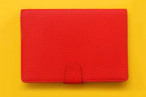 Red notebook on yellow background. Office supplies for work. Stock-Fotos