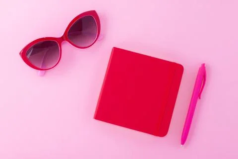 A red notepad on a light pink background. Stock Photos