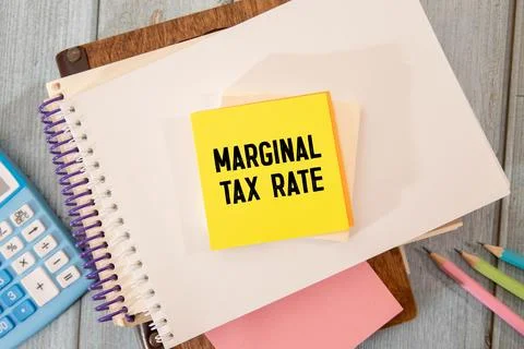 On a red notepad a sheet of paper with text Marginal tax rate. Stock Photos