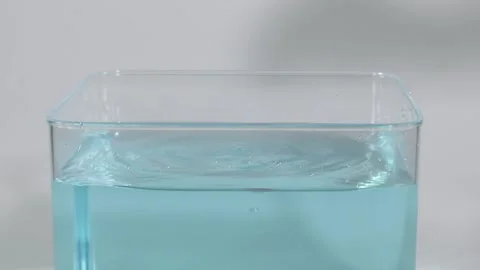 Red Object Dropped into Clear Water Tank for Physics Experiment Video stock 327432337