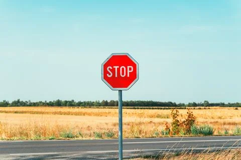 Red octagonal stop traffic sign on a country road. Concept of road safety, .. Stock Photos