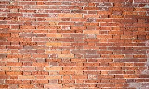 Red old brick wall with gray cement joints Stock Photos