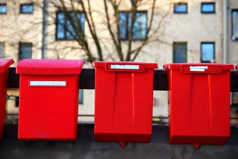 Red old post boxes with a house in a background Stock Photos