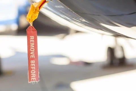 Red old seedy Remove Before Flight Tag on an airplane fuselage Fotos de archivo