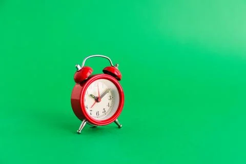 Red old style clock on green Stock Photos