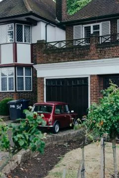 Red oldstyle Mini parked in front of the garage Stock Photos