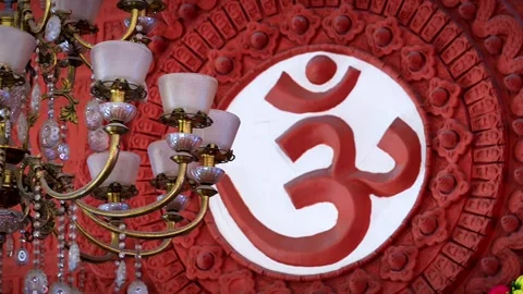 Red Om symbol on white background with hanging chandeliers, Hindu spiritual.. Stock Footage 346729848