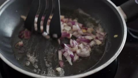 Red onion cooking in a pan close up video Stock Footage 146804298