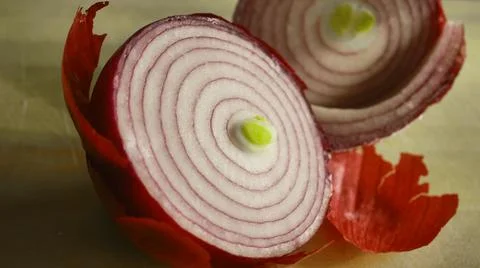 Red onion cut in half exposing onion layers on table  Stock Photos