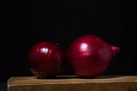 Red onion isolated on a black background. Healthy vegetable. Stock Photos