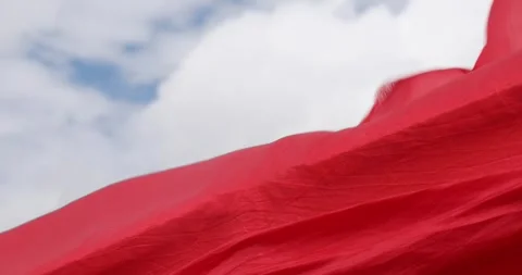 Red only color flag , textile material blowing in the wind against the blue.. Stock Footage 308889482