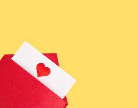 Red open envelope with a sheet of paper with a heart on a yellow background w Stock Photos