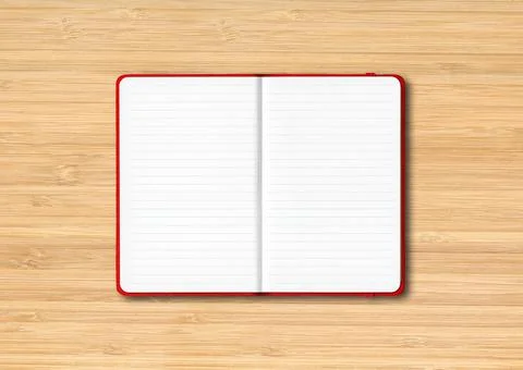 Red open lined notebook isolated on wooden background Foto stock