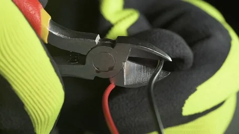 Red or black: indecision about which wire to cut with electrician's scissors Stock Footage 77766740