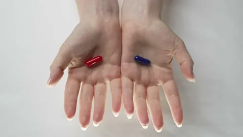 Red or blue tablet. There are red and blue pills in women's hands. Vidéo 187191703