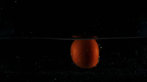 Red orange tomato dropped falling in water with lot of splashes Stock Footage 148737051