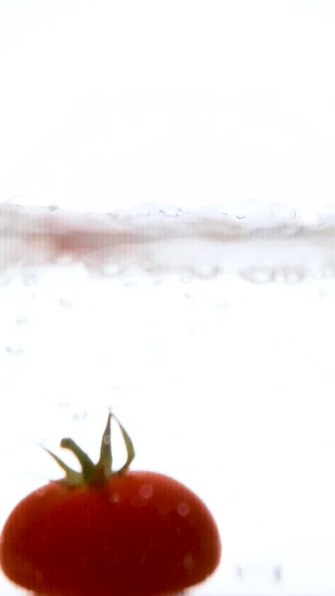 Red organic cherry tomatoes falling and splashing into fresh water, in slow m Stock Footage 281848620