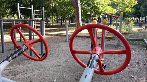 Red outdoor exercise machine in a city park, fitness training. Stock Footage 342994298