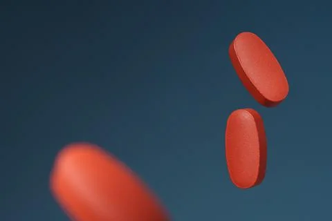 Red oval tablets on a blue background. Advertising banner with space for text Stock Photos