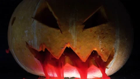 Red paint flows from the mouth of a pumpkin Stock Footage 165995376