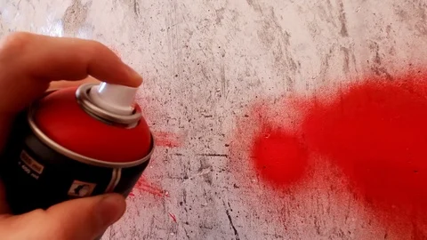 Red paint for graffiti. A hand with a spray can draws graffiti on the wall. Stock Footage 126053508