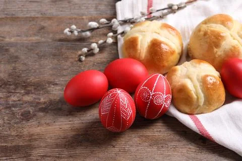 Red painted Easter eggs and buns on wooden table. Space for text Stock Photos