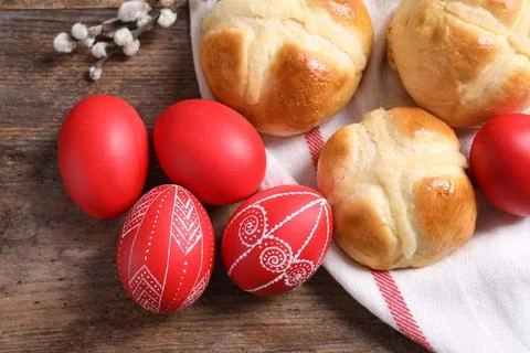 Red painted Easter eggs and buns on wooden table, top view Stock Photos
