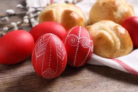 Red painted Easter eggs and buns on wooden table, closeup Stock Photos