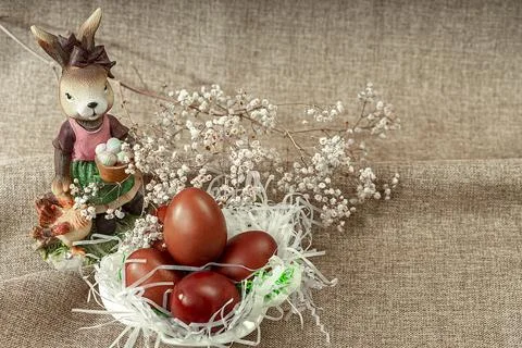 Red painted Easter eggs, spring flowers and a rabbit. Easter holiday decora.. Stock Photos