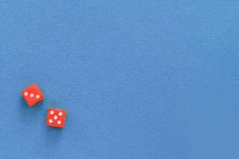 Red pair of dice on a blue surface. Top view, copy space. Gambling background Stock Photos