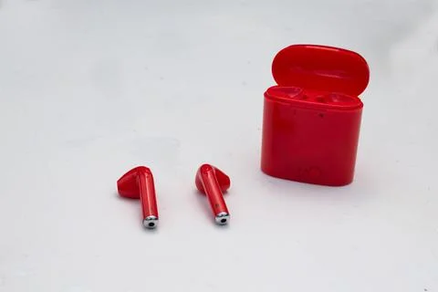 A red pair of wireless earbuds and case Stock Photos