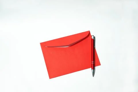 Red paper envelope and red ball pen on white background. Stock Photos
