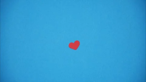 Red paper heart that grows from small to big on blue background. Stop motion Stock Footage 299636116