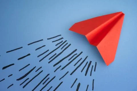 Red paper plane on a blue background Stock Photos