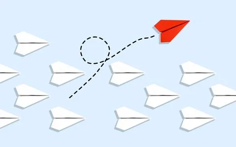 Red paper plane flying in a different direction from a group of white paper.. Stock Photos