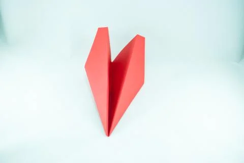 Red paper plane on a white background, isolated.  Stock Photos