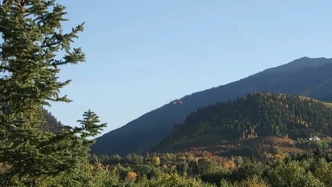 Red Paraglider sails through high altitude mountain range in Aspen Colorado. Stock Footage 97418553
