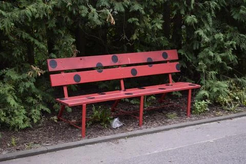 Red park bench with black dots in ladybug style Stock Photos